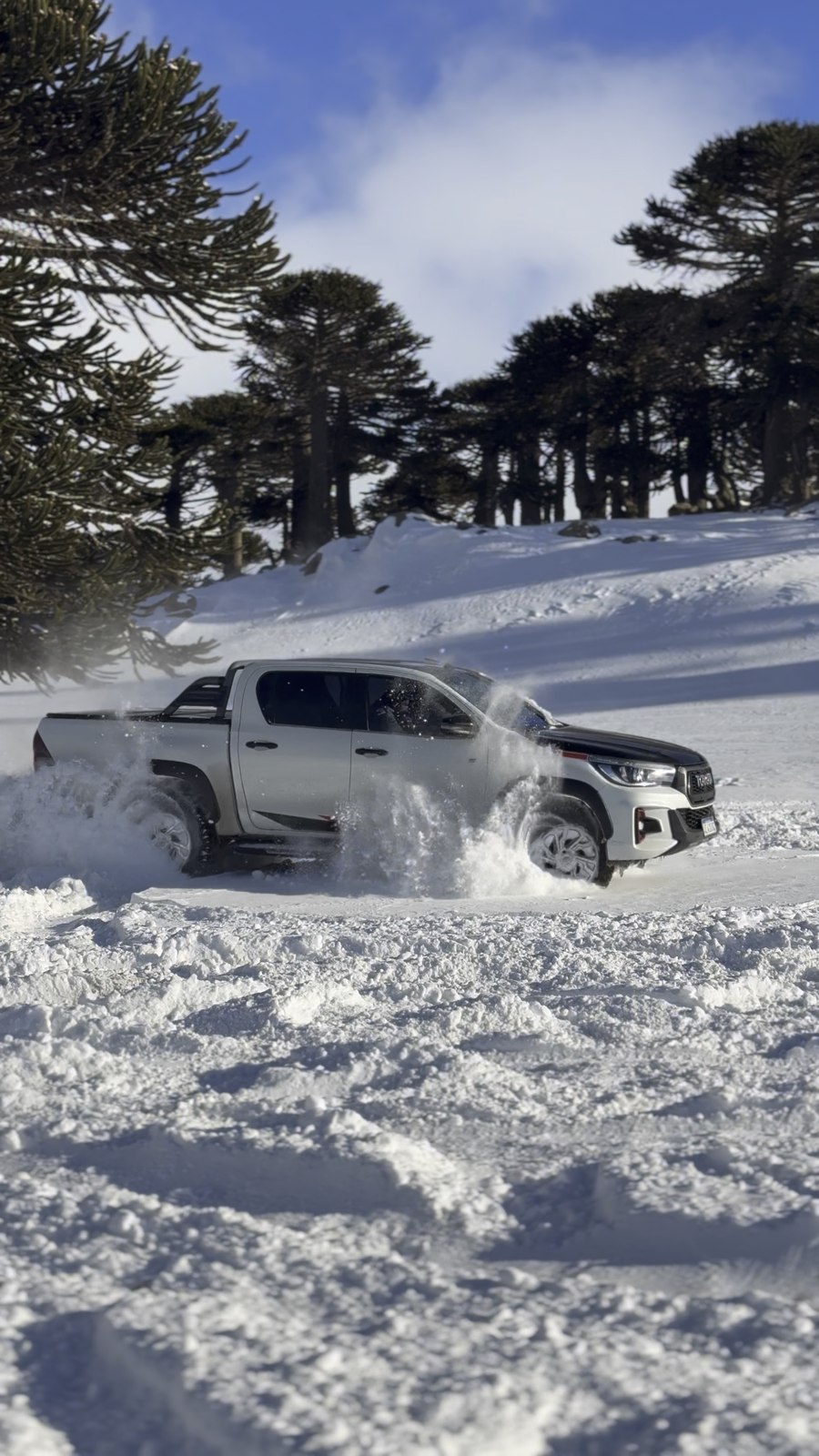 Toyota Hilux GR Sport de Transportes Lucas derrapando en la nieve entre araucarias